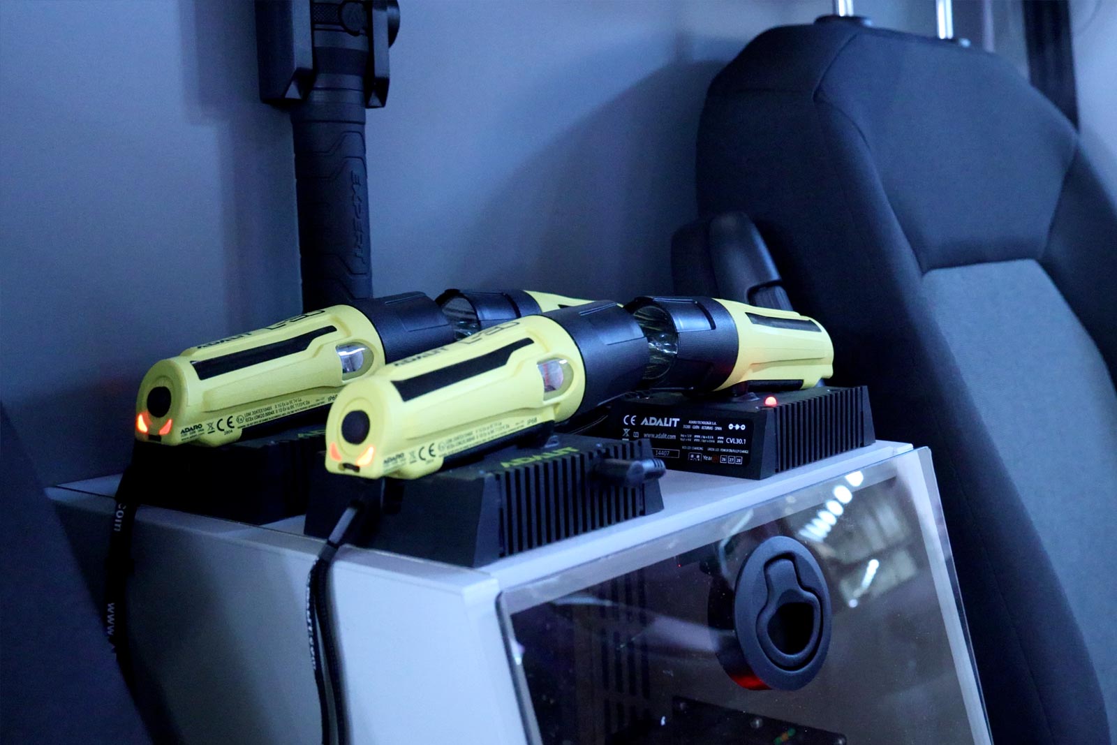 Professional rechargeable flashlights sitting in their charging docks inside an emergency vehicle